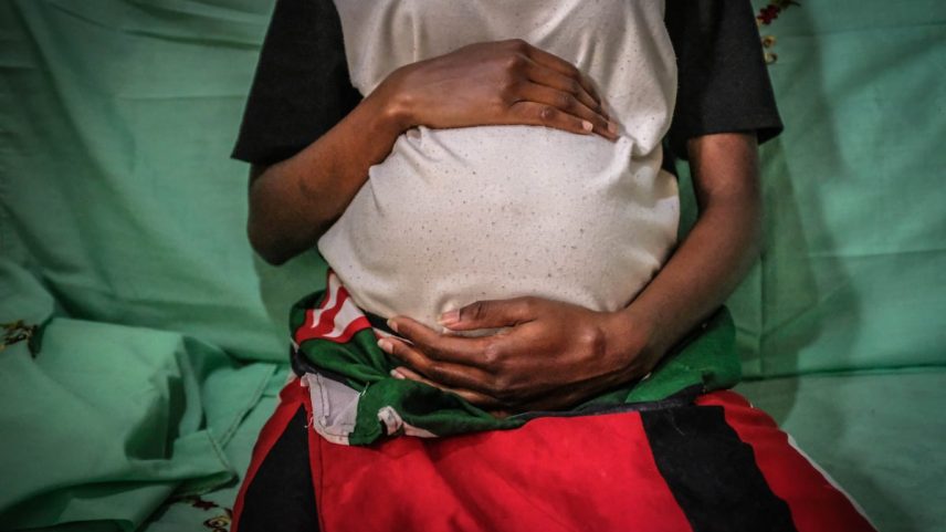 Mercy Kwamboka, uma mãe de 19 anos, segura seu ventre de sete meses nos bairros marginalizados de Kibera, em Nairobi. (Foto: SOPA Images/LightRocket via Getty Images)
