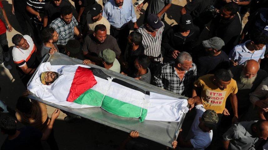 Dolientes carregam um corpo durante o funeral de palestinos que morreram por fogo israelense enquanto tentavam receber ajuda na segunda-feira, e de palestinos que morreram em ataques israelenses noturnos, no hospital Al-Shifa da cidade de Gaza, na terça-feira. (Foto: Mahmoud Issa/REUTERS)