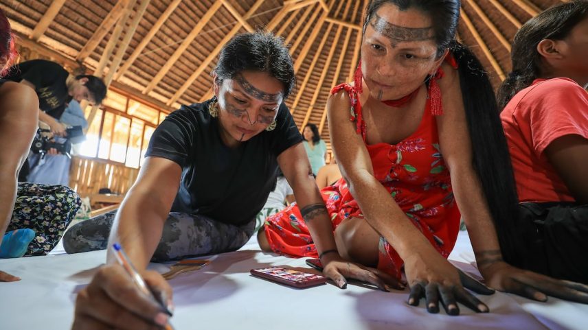 Um grupo de mulheres indígenas pinta um telar na selva de Sarayaku, Equador, em 28 de junho de 2025 (Foto: JOSÉ JÁCOME/EFE)