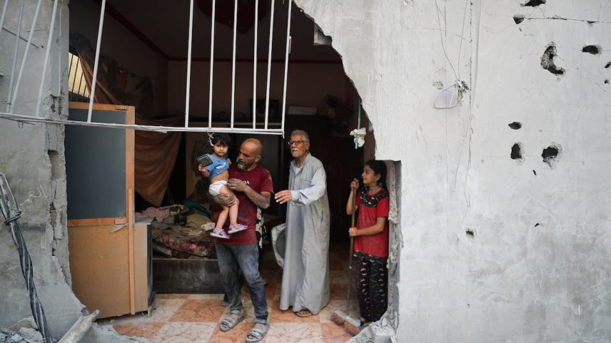 Um grupo de palestinos contempla os destroços provocados por um bombardeio israelense na Cidade de Gaza nesta sexta-feira. (Foto: Mahmoud Issa/REUTERS)