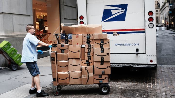 Um trabalhador dos Correios dos EUA entrega caixas da Amazon do lado de fora da Bolsa de Valores de Nova York (NYSE) em 11 de outubro de 2018, na cidade de Nova York. (Foto: Spencer Platt | Getty Images)