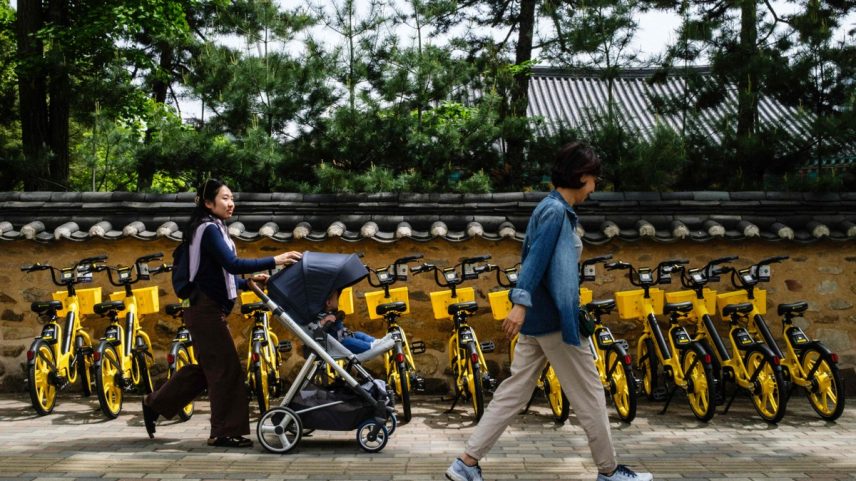 Mãe passeia com o filho no carrinho: cena cada vez mais rara em Seul (Foto: ANTHONY WALLACE / AFP)