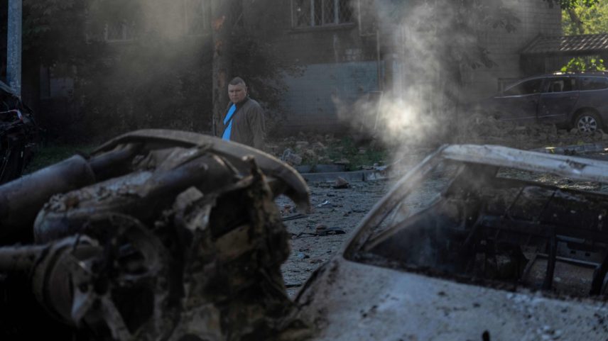 Homem caminha por veículos atingidos por bombardeios russos em Kiev (Foto: Oleksii Filippov/AFP)