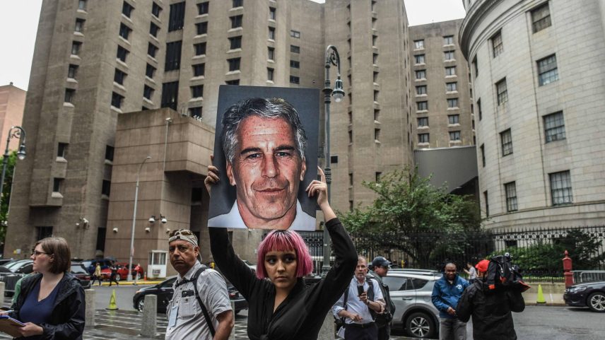 Manifestante segura foto do magnata Jeffrey Epstein em frente à prisão onde ele foi encontrado morto em 2019, em Nova York, nos EUA (Foto: Stephanie Keith - 8.jul.19/AFP)