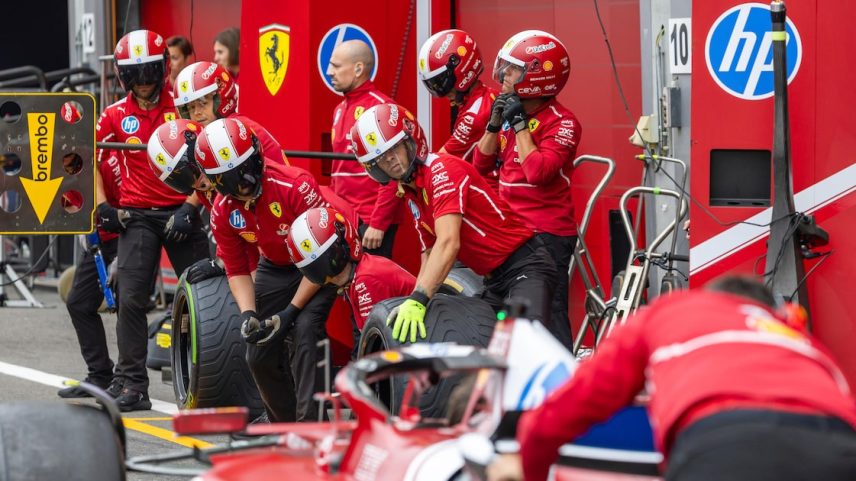 Membros da equipe trabalham em frente à garagem da Ferrari antes do GP de Fórmula 1 no autódromo de Spa-Francorchamps, em 24 de julho de 2025. (Foto: Geert Vanden Wijngaert/AP)