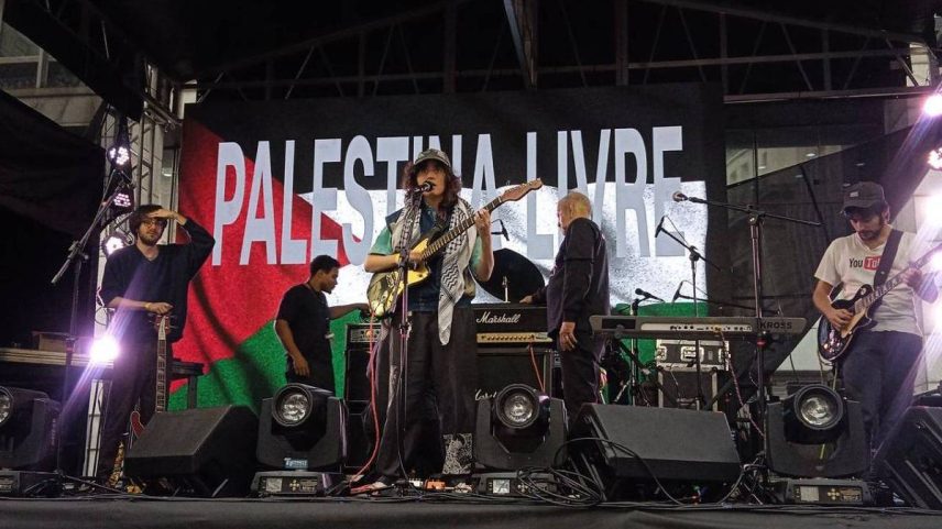 A banda Sophia Chablau e uma Enorme Perda de Tempo exibe telão com a mensagem 'Palestina livre' durante show na praça do Patriarca, em São Paulo (Foto: Reprodução)