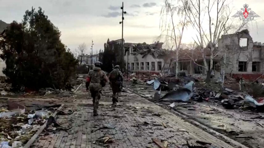 Militares russos passam por um prédio destruído na cidade de Sudzha, que foi recentemente retomada pelas forças armadas russas durante o conflito Rússia-Ucrânia na região de Kursk, Rússia, nesta imagem estática de um vídeo divulgado em 15 de março de 2025. (Foto: Ministério da Defesa Russo/Divulgação via REUTERS)