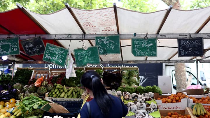 Um cliente está em frente a uma barraca de frutas e vegetais em um mercado ao ar livre em Paris no dia 15 de julho de 2025. (Foto: Behrouz Mehri | Afp | Getty Images)