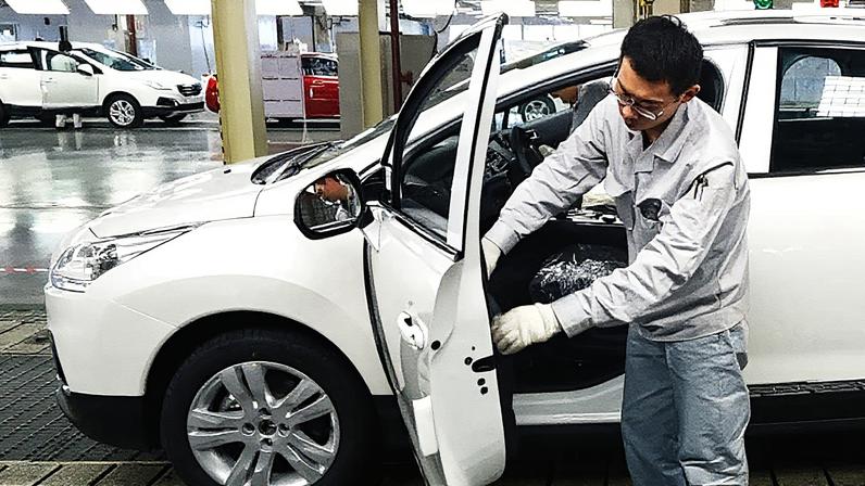 Um trabalhador monta um veículo utilitário esportivo compacto Peugeot 3008 na linha de produção em uma fábrica operada pela Dongfeng Peugeot-Citroen Automobile Ltd., a joint venture entre a Dongfeng Motor Corp. e a PSA Peugeot Citroen, em Wuhan, China. (Foto: Tomohiro Ohsumi | Bloomberg | Getty Images)