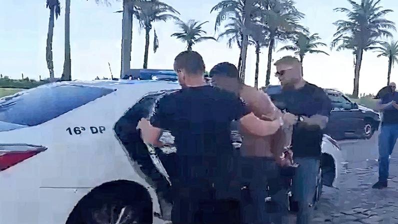 Um dos suspeitos entrando na viatura da Polícia Civil (Foto: Reprodução)