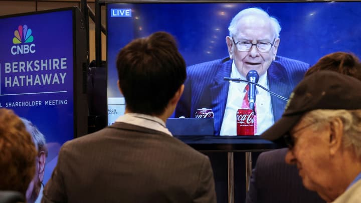 As pessoas assistem enquanto o presidente da Berkshire Hathaway, Warren Buffett, é visto em uma tela falando na reunião anual de acionistas da Berkshire Hathaway em Omaha, Nebraska, em 3 de maio de 2025. (Foto: Brendan McDermid | Reuters)