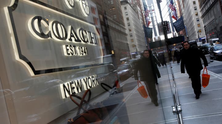Pessoas passam em frente a uma loja Coach na Madison Avenue, em Nova York. (Foto: Carlo Allegri | Reuters)