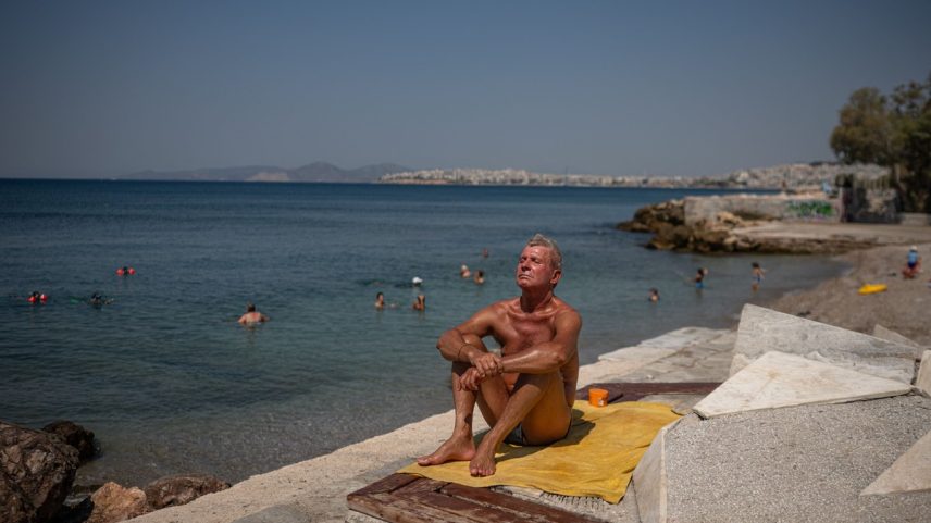 Homem curte praia em Atenas, na Grécia (Foto: Angelos Tzortznis/AFP)