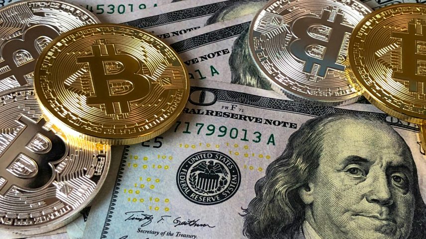 Representação de diversificação de ativos com dólares e representações físicas de Bitcoin e criptoativos (Foto: Pexels / David McBee)