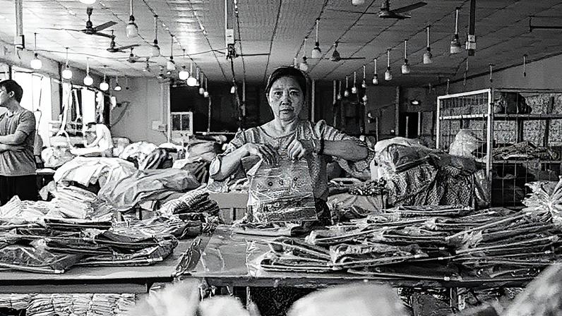 Funcionário embala roupas em uma fábrica de vestuário na cidade de Guangzhou, na província de Guangdong, China (Foto: Reprodução)