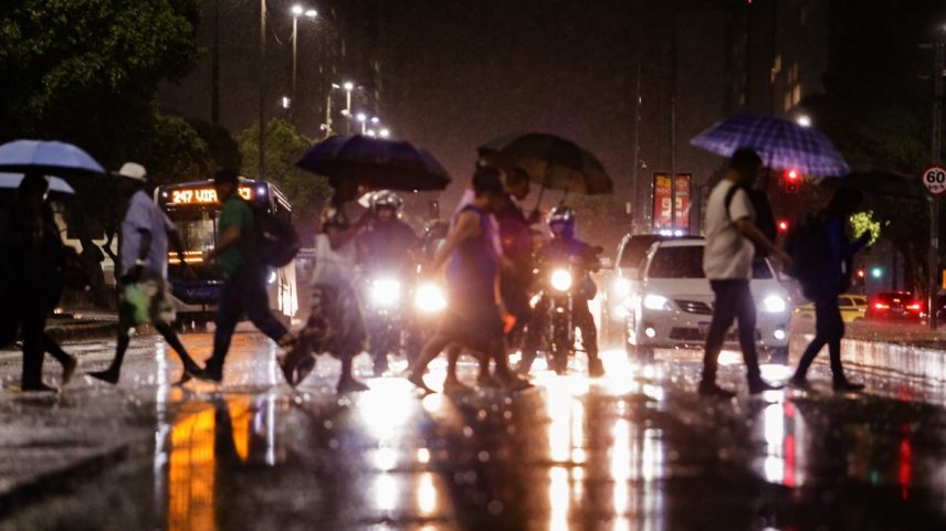 Pedestres se protegem da chuva no Rio de Janeiro (Foto: Marcelo Theobald / Agência O Globo)