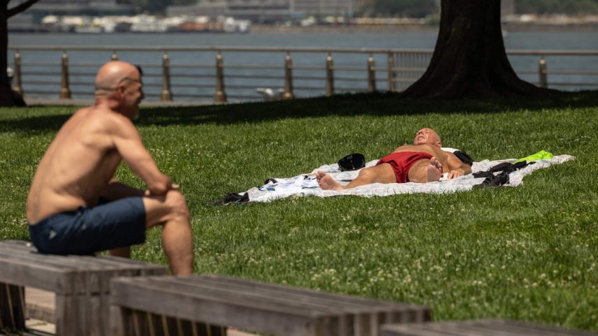Pessoas sentam-se ao longo do rio Hudson durante onda de calor em junho de 2024 na cidade de Nova York (Foto: Yuki Iwamura/AFP)