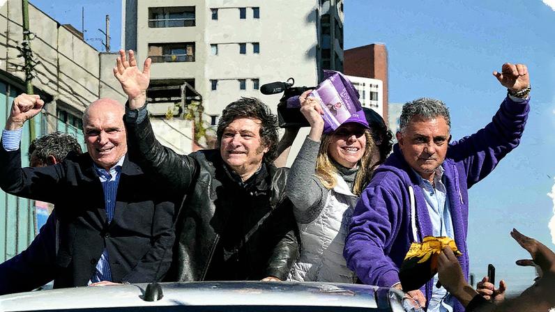 Javier Milei (ao centro) acena ao lado da irmã Karina Milei e outras autoridades durante uma carreata: presidente foi alvo de protestos e pedradas (Foto: Juan Mabromata/AFP)
