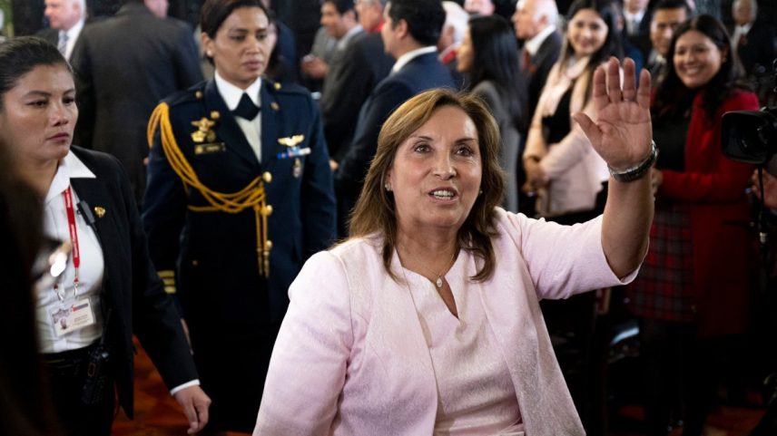 A presidente do Peru, Dina Boluarte, acena para a imprensa após uma cerimônia de promulgação de uma lei de anistia para militares e policiais processados por violações de direitos humanos no Palácio do Governo em Lima, em 13 de agosto de 2025 (Foto: Ernesto BENAVIDES / AFP)