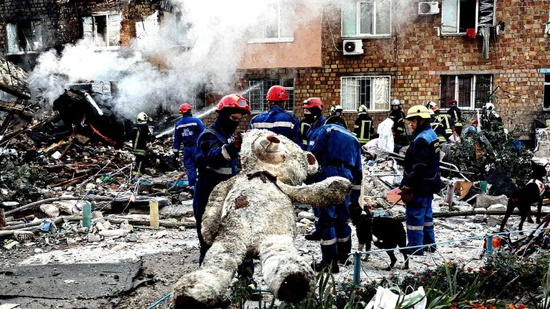 Socorristas com um urso de pelúcia de um apartamento atingido pelo ataque russo a Kiev (Foto: Thomas Peter/Reuters)