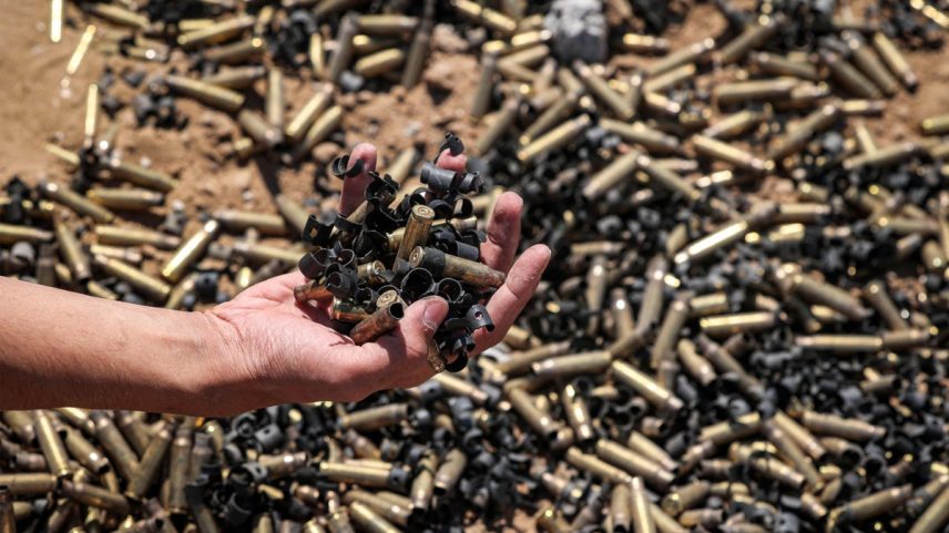 Pessoa segura cápsulas de munição em Khan Yunis, na Faixa de Gaza, após retirada temporária das tropas israelenses da área (Foto: AFP)