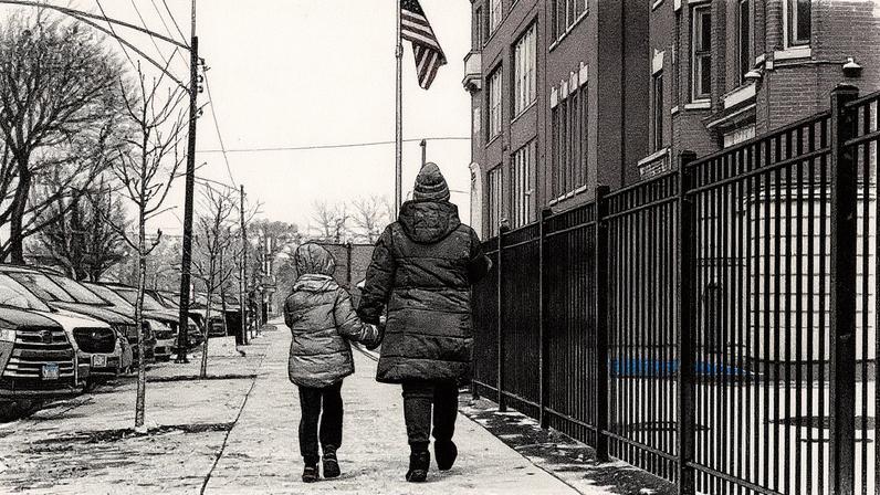 Uma mulher e uma criança caminham em frente a uma escola em Chicago, nos EUA (Foto: Vincent Alban - 24.jan.2025/Reuters)
