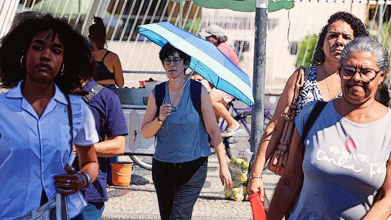 Transeuntes se protegem do forte calor nas ruas do centro da cidade do Rio de Janeiro (Foto: Tânia Rêgo/Agência Brasil)