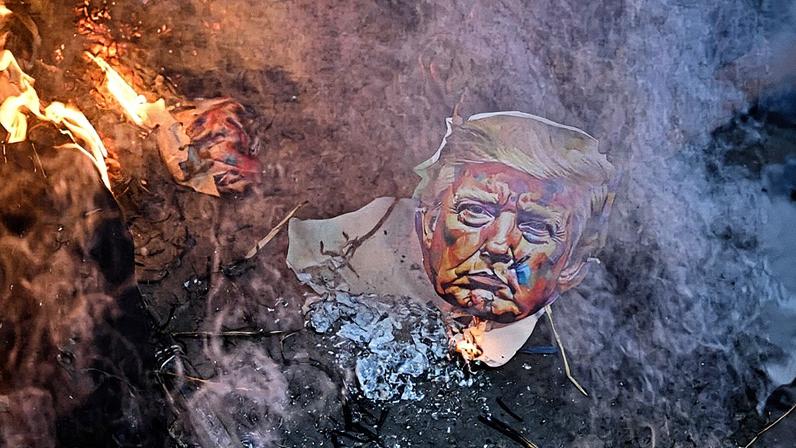 Ativistas de diferentes sindicatos queimam um boneco do presidente dos EUA, Donald Trump, para protestar contra os recentes aumentos de tarifas dos EUA sobre a Índia, vistos em Kolkata no dia 13 de agosto. (Foto: Dibyangshu Sarkar/AFP via Getty Images)