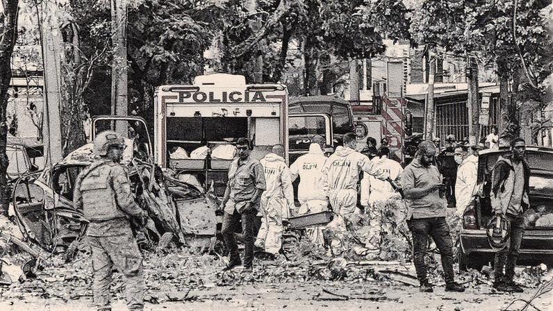 Membros de uma equipe forense removem um corpo próximo aos escombros após a explosão de um veículo de carga perto de uma base da Força Aeroespacial Colombiana, em um dos dois ataques atribuídos a grupos dissidentes das FARC que causaram várias vítimas, segundo autoridades, em Cali, Colômbia, em 21 de agosto de 2025. (Foto: REUTERS/Stringer)