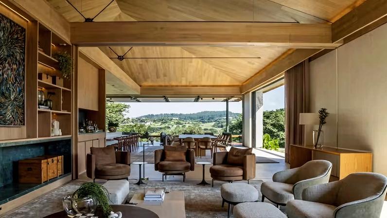 ÁREA SOCIAL | Ligado à área gourmet, o ambiente tem poltronas e mesas de centro e de apoio da Minotti. O teto de carvalho europeu segue a materialidade do projeto. Tapete da Phenicia