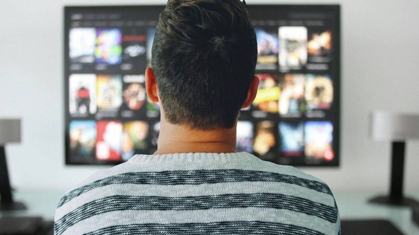 Homem assiste a televisão que exibe catálogo de streaming (Foto: Pixabay)
