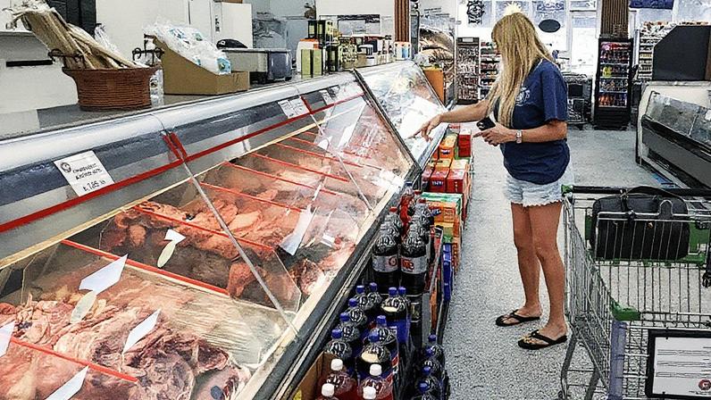 Lisa Lungaro faz compras no balcão de carnes em um supermercado em 22 de julho de 2025, em Miami, Flórida. (Foto: Joe Raedle | Getty Images)
