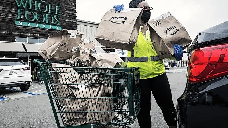 Um contratante independente usando máscara e luvas carrega sacolas de supermercado Amazon Prime em um carro do lado de fora de um Whole Foods Market em Berkeley, Califórnia, em 7 de outubro de 2020. (Foto: David Paul Morris | Bloomberg | Getty Images)