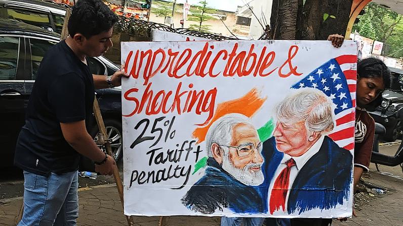 Estudantes da Gurukul School of Art carregam um cartaz do Primeiro-Ministro da Índia, Narendra Modi, e do Presidente dos EUA, Donald Trump, sobre a Índia, em frente à escola. O Presidente dos EUA, Donald Trump, impôs uma tarifa de 25% sobre a Índia, além de penalidades por comprar petróleo e equipamentos militares da Rússia. (Foto: Sopa Images | Lightrocket | Getty Images)