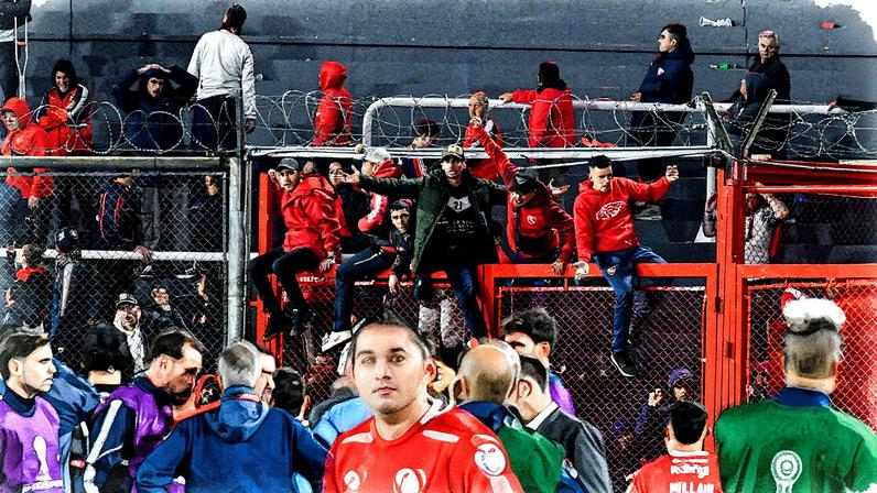Torcedores se penduram nas grades do estádio Libertadores de América durante confronto entre Independiente e Universidad de Chile, em Avellaneda (Foto: Facundo Morales - 20.ago.2025/Reuters)