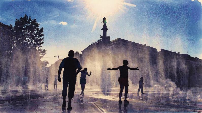 Pessoas ficam embaixo de fonte para se refrescar durante onda de calor em Viena, na Áustria (Foto: Alex Halada - 15.ago.25/AFP)