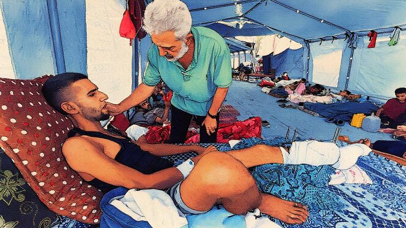 Abdel Rahman Abu Shawish, que terá que amputar o pé, está deitado em um colchão trazido de sua casa ao lado de seu pai no hospital Nasser em Jan Yunis (Gaza). (Foto: Mohammed Soulaimane)