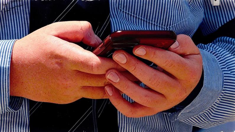 Um estudante usa seu celular em Melbourne em 27 de novembro de 2024 (Foto: William WEST / AFP)