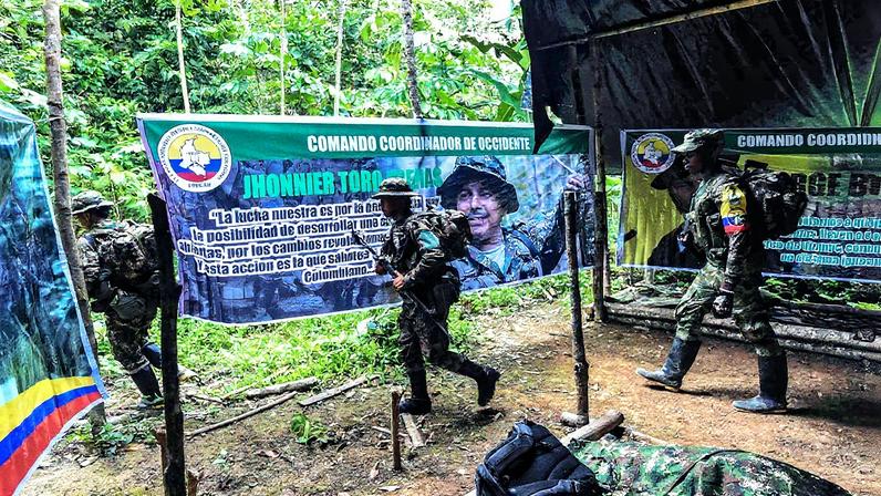Guerrilheiros dissidentes da Frente 30 das FARC-EP Rafael Aguilera caminham em um acampamento no departamento colombiano de Nariño, em 1º de março de 2023 (Foto: Joaquín SARMIENTO / AFP)