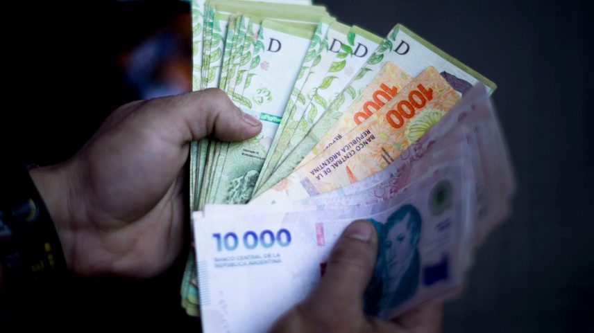Um trabalhador de entregas da Pedidos Ya exibe os pesos argentinos ganhos durante a entrega de comida em Buenos Aires, Argentina, na segunda-feira, 16 de dezembro de 2024 (Foto: Tomas Cuesta/Bloomberg)