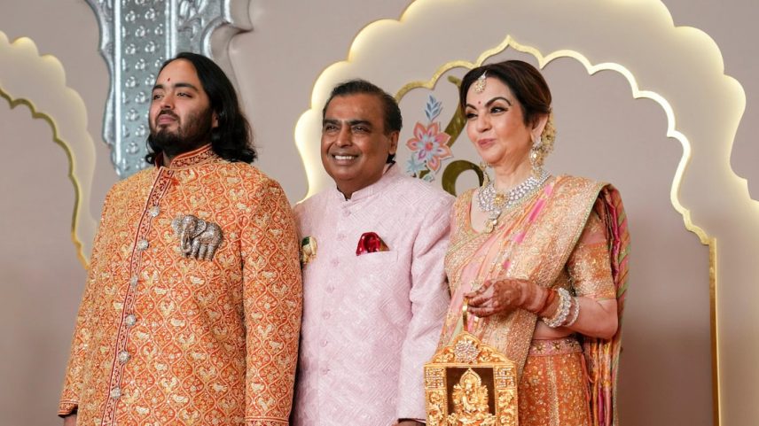 O bilionário Mukesh Ambani (C), no casamento de seu filho, Anant (E), e ao lado de sua esposa, Nita (Foto: Rajanish Kakade/AP)