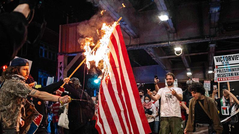 Manifestantes pró-Palestina queimam bandeira americana na rua perto de local onde a Convenção Nacional Democrata seria realizada (Foto: Jim Vondruska - 22.ago.2024/Getty Images via AFP)