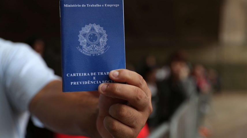 Homem mostra carteira de trabalho no centro de São Paulo (Foto: Amanda Perobelli/Reuters)