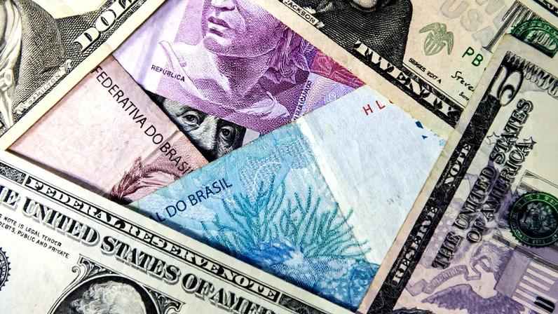 Notas de dólar e real dispostas sobre uma superfície (Foto: Reprodução)