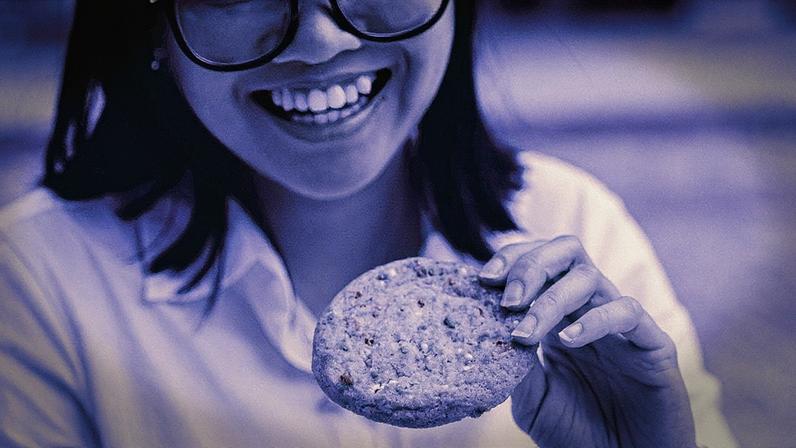 Naomi Barrales, que separa uma parte de seu salário para guloseimas, com um doce da Insomnia Cookies, uma rede que também serve sorvete, no Gansevoort Plaza, em Manhattan, em 31 de julho de 2025. (Foto: Amir Hamja/The New York Times)