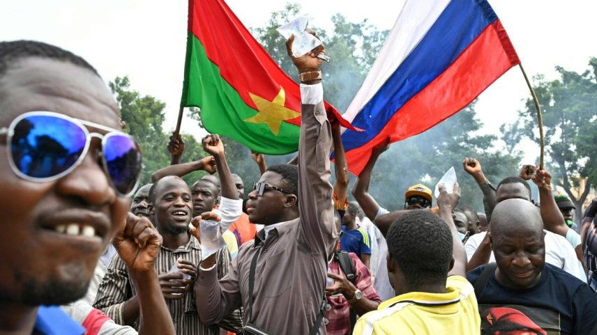 Apoiadores do novo líder da junta de Burkina Faso, Ibrahim Traore, seguram bandeiras nacionais de Burkina Faso e da Rússia durante uma manifestação perto da sede nacional de rádio e televisão (RTB) em Ouagadougou (Foto: ISSOUF SANOGO/AFP)