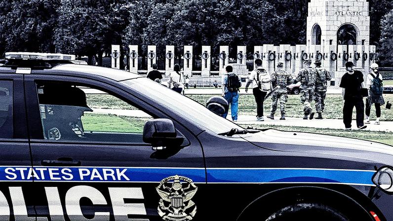 Carro da polícia de Washington em frente ao monumento da Segunda Guerra, com soldados da Guarda Nacional caminhando ao lado de civis (Foto: Reprodução)