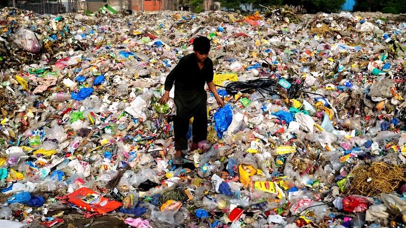 Catador de materiais recicláveis em um lixão em Lahore, no Paquistão. (Foto: K.M. Chaudary/AP)