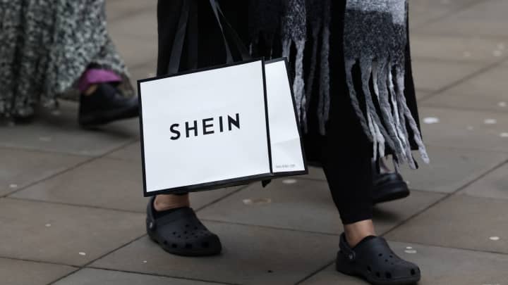 Uma compradora carrega uma bolsa com mercadorias promocionais enquanto visita a turnê de Natal do varejista de moda Shein, em Manchester, Grã-Bretanha, 13 de dezembro de 2024. (Foto: Temilade Adelaja | Reuters)