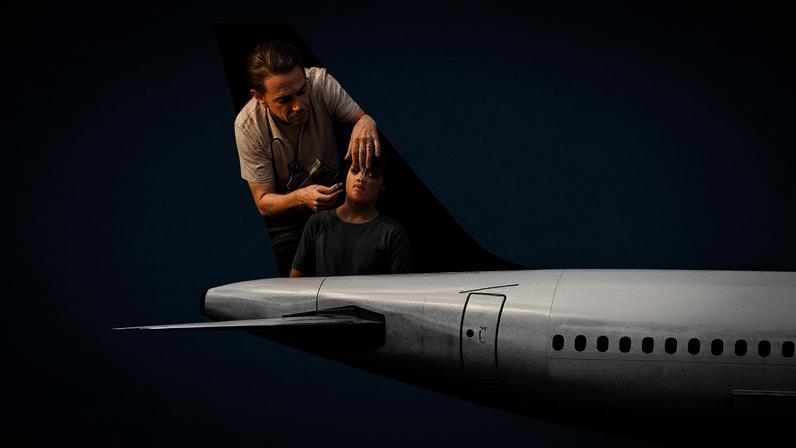 A photo of a woman helping a child on the tail of an airplane